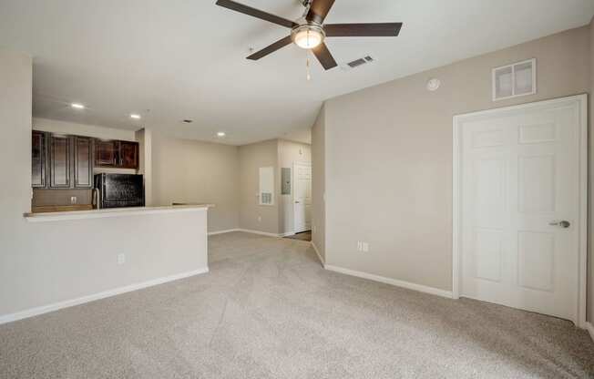 the living room and kitchen in a new home with a ceiling fan