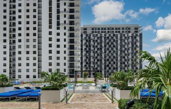 A modern building with a pool in front. at Palma, Doral, FL, 33166