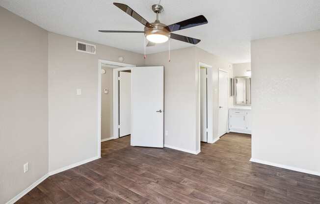 a bedroom with hardwood flooring and a ceiling fan