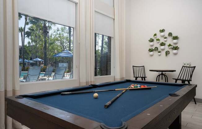 A pool table with a blue cloth and a white ball on it.