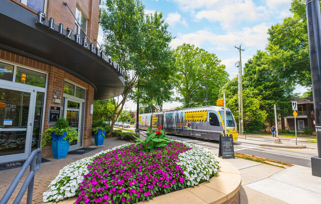 a train traveling down a street next to a building