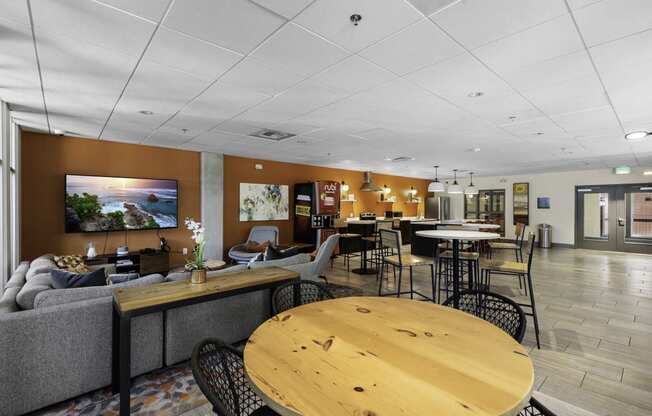 a lounge area with tables and chairs and a resident community kitchen in the background at Sedona Apartments, Seattle, Washington