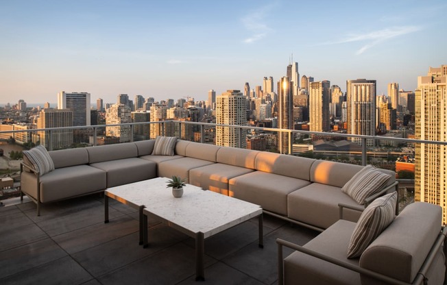 a terrace with a couch and a table overlooking a city