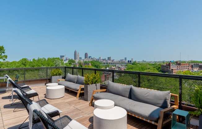 a view of the Cleveland skyline from a rooftop deck with couches and tables at TREO Apartments, Cleveland, OH