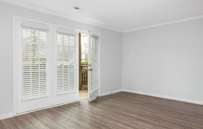A room with white walls and a wooden floor at Ashley Oaks Apartments in Greensboro, North Carolina