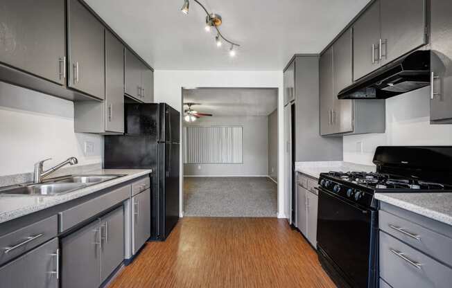 an empty kitchen with black appliances and white cabinets