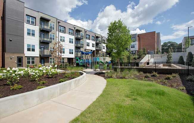 A modern apartment complex with a playground in the foreground.