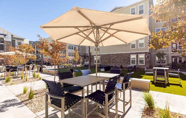 A patio with a table and chairs under an umbrella.
