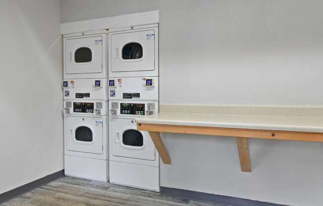 a laundry room with washing machines and a bench