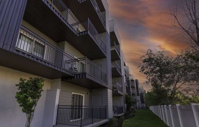 a row of apartments with balconies at sunset