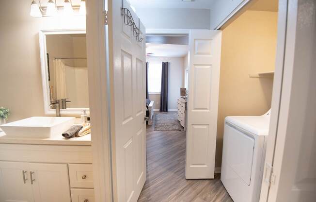 A bathroom with a white sink and a white door.