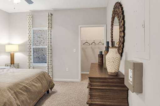 A bedroom with a bed, dresser, and mirror.