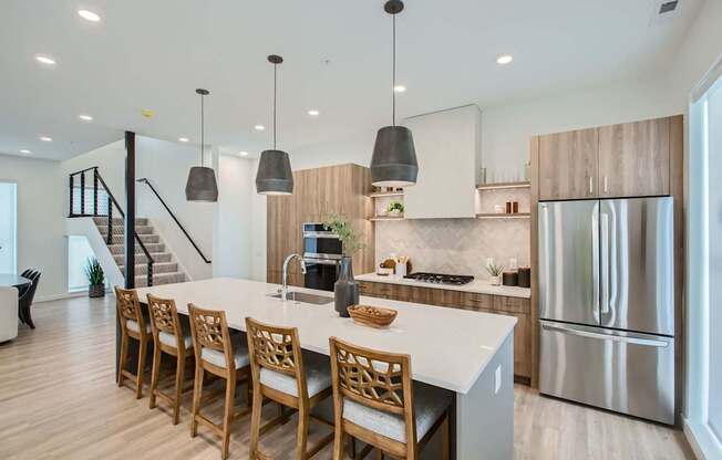 a kitchen with a large island and a stainless steel refrigerator