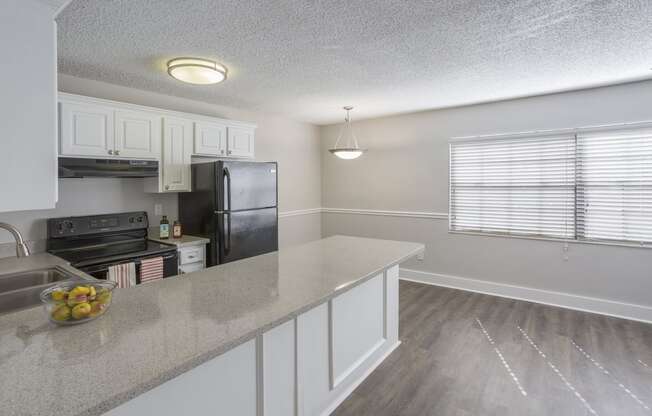 a kitchen with white cabinets and a granite counter top