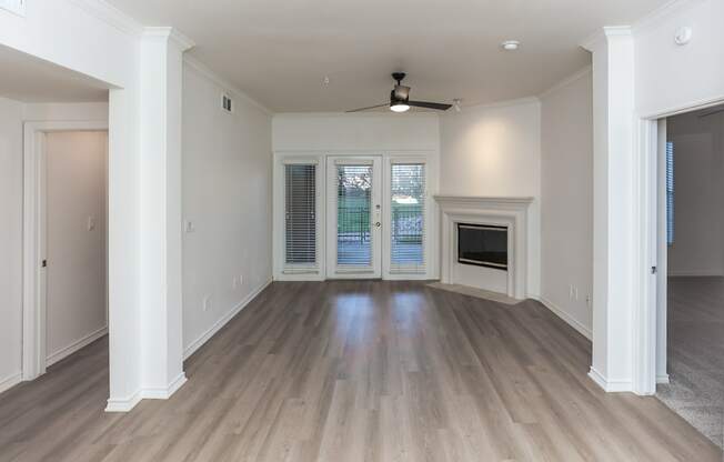 A spacious room with a ceiling fan and a fireplace.