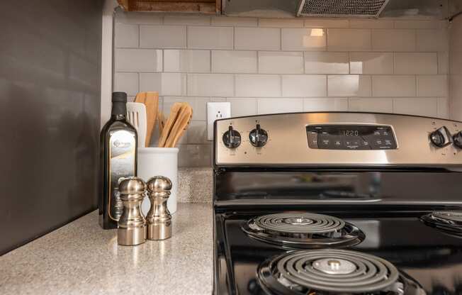 a kitchen with a stove and a bottle of wine on the counter