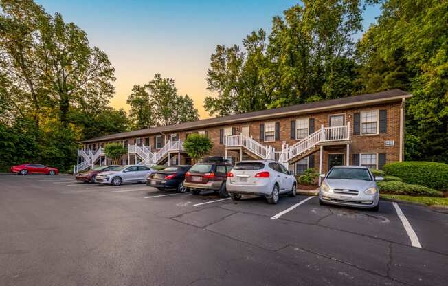 a parking lot with cars in front of an apartment building