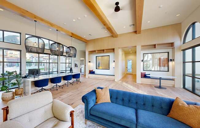 A blue couch with a white cushion is in the middle of a room with a wooden floor at The Villas at Anacapa Canyon, Camarillo, 93012