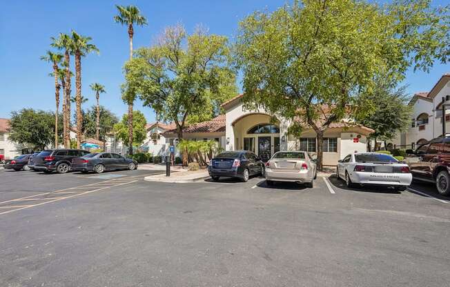 A parking lot with cars and palm trees.