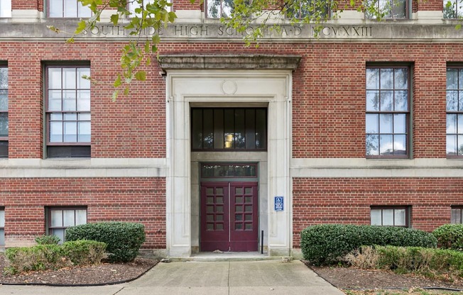 A red brick building with a white arched entrance and a blue handicap sign.