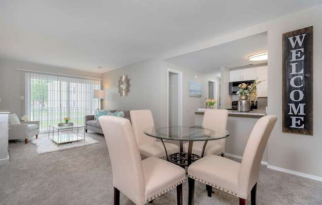 A dining room with a glass table and chairs.