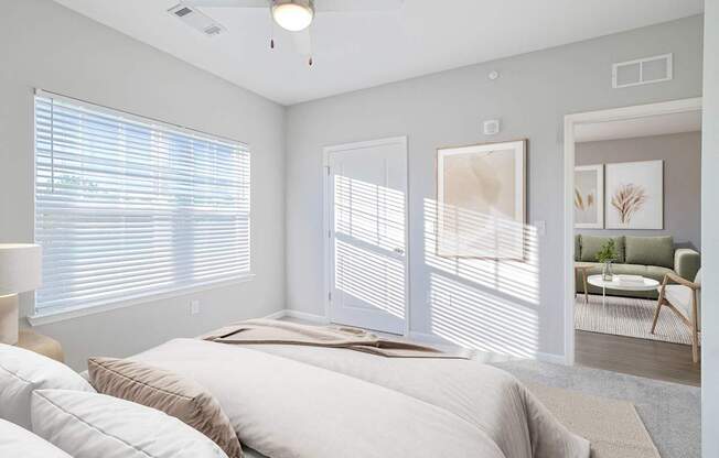 A room with a ceiling fan and a window with blinds.