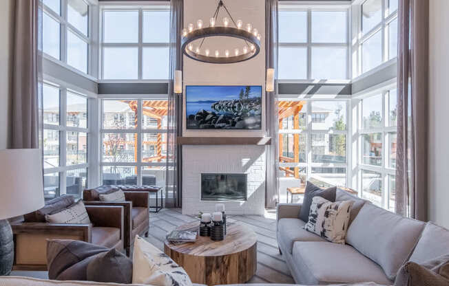 a living room with a couch and a fireplace and large windows
