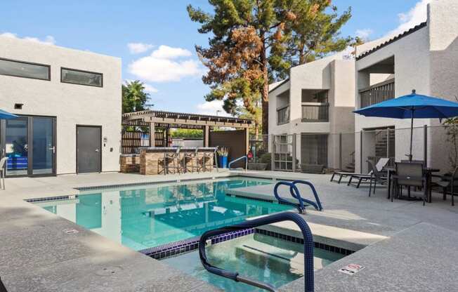 Del Sol Apartments Pool with Lounge Chairs and BBQ Area