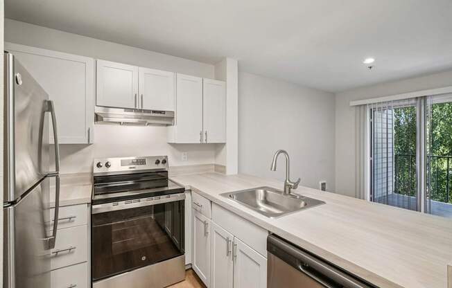 A modern kitchen with stainless steel appliances and white cabinets.