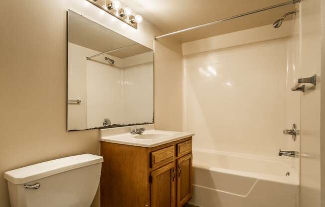 a bathroom with a toilet sink and mirror and a shower at Pheasant Run in Lafayette, IN 47909