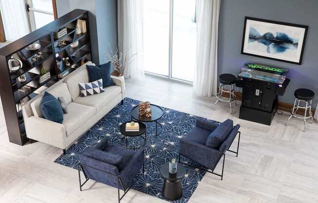 A modern living room with a white sofa, a blue chair, and a coffee table with a starry pattern.