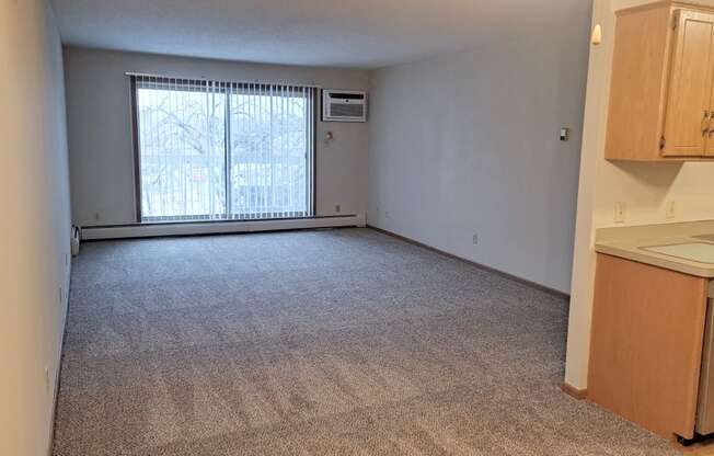 an empty kitchen and living room with a large window