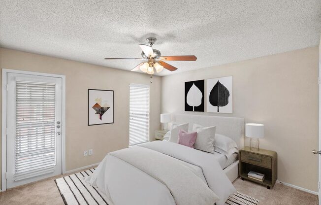 A bedroom with a large bed and a ceiling fan.