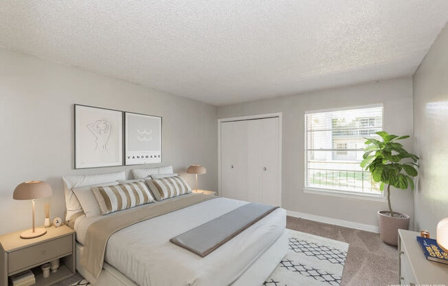 Model Bedroom with Carpet and Window View at Indigo Park Apartments in Albuquerque, NM.