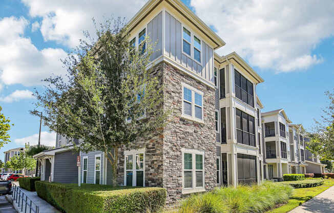 Multi-story residential buildings with attached garages and clean walkways at Lotus at Starkey Ranch in Odessa, Florida.