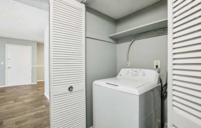A washing machine is sitting in a laundry room.