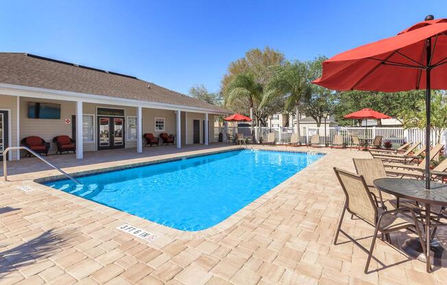 a red umbrella next to a pool of water