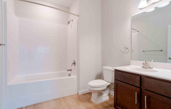 A white bathroom with a toilet, sink, and bathtub.