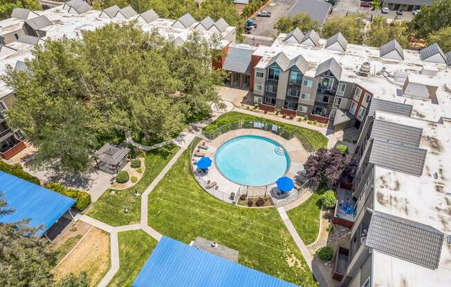 A swimming pool is surrounded by a grassy area and a building.