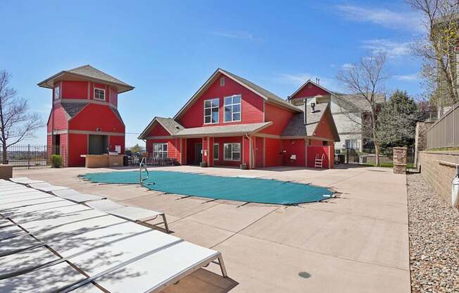 A red house with a pool in the backyard.