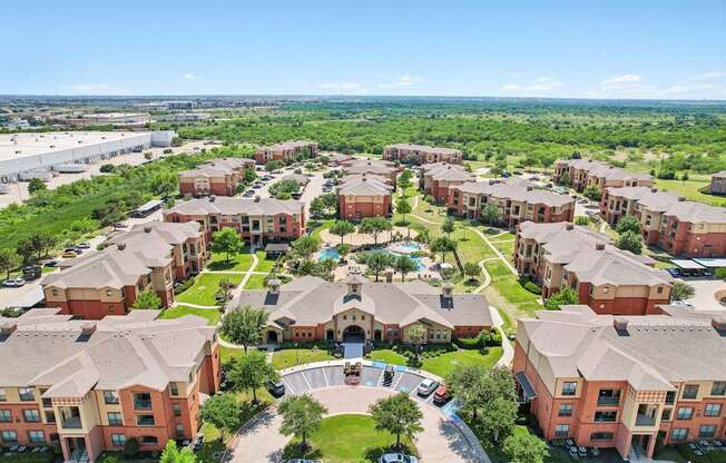 A large apartment complex with a central courtyard surrounded by greenery.