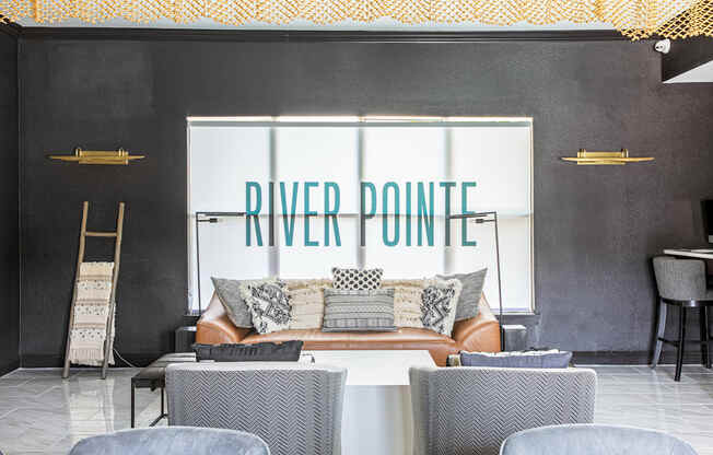 a living room with a couch and chairs in front of a window with the words river point