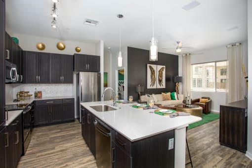 a large kitchen and living room with a white counter top