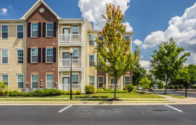 an apartment building on the corner of a street with trees