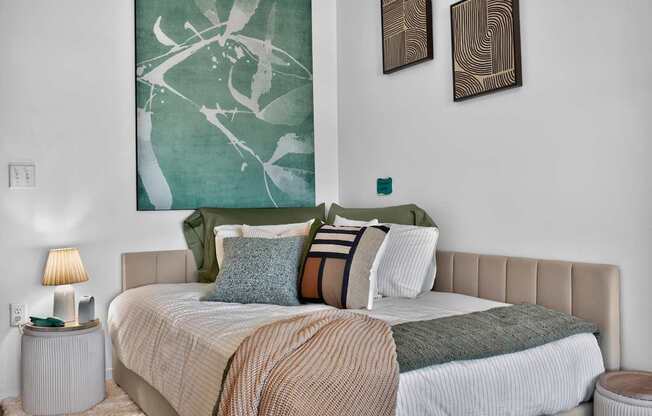 A bedroom with a large bed and two wall art pieces at The Indie in Allston.