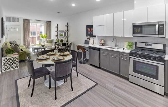 a kitchen and living room with stainless steel appliances and a table