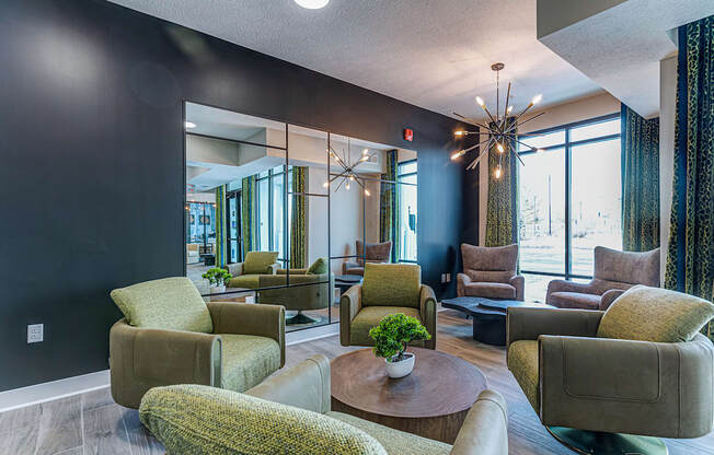 A living room with a large mirror, a chandelier, and a variety of chairs and a coffee table.at Tiffany Flats, Columbus, 43231