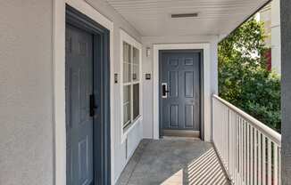 the front door of a house with blue doors and a porch