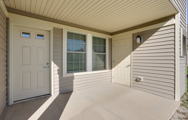 the front porch of a home with a white door