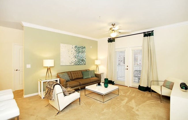 Living room with ceiling fan and door to patio